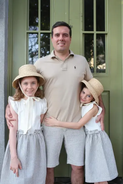 Pai com filhas em looks coordenados Aurora Bebê no mega menu