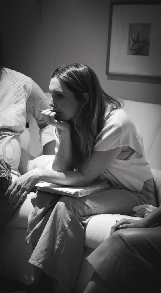 Registro em preto e branco de Helen Marini em um momento de conversa e criação.